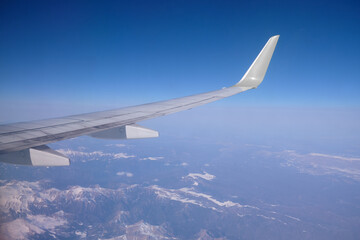 Caucasus mountains with snow peaks in aerial winter scene. Aerial view from plane.