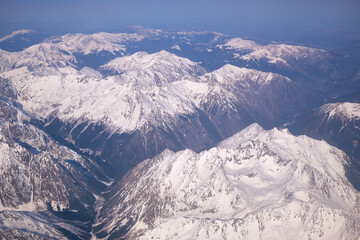 Caucasus mountains with snow peaks in aerial winter scene. Aerial view from plane.