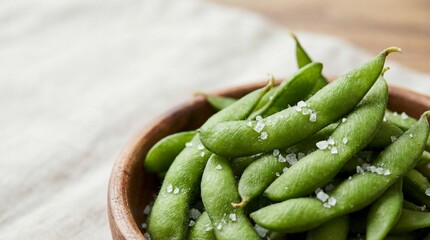 Edamame beans with salt in a wooden bowl, macro texture, healthy green color. copy space for text