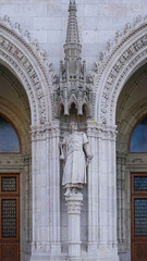 Obraz premium Entrance to the ornate neo-gothic Hungarian Parliament building. Located on the banks of the Danube River, in the center of Budapest
