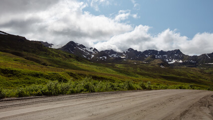 Fototapeta premium Country Dirt gravel road through Hatcher Pass valley near Palmer Alaska USA