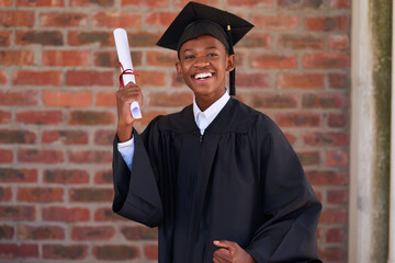 Happy, black child and student portrait with graduation certificate for qualification or achievement. Boy, kid or teenager with smile for certification, scholarship or school graduate on campus
