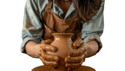A person with hands covered in clay shapes a pottery vase on a spinning wheel
