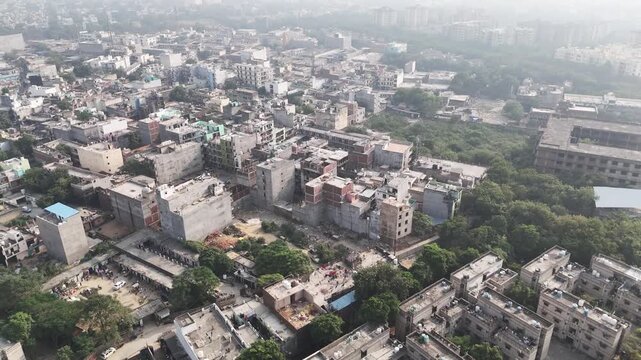 Wide aerial panorama of Greater Noida, capturing uniform apartment complexes, green corridors, and quiet roads beneath a pollution-heavy northern Indian sky.