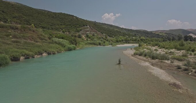 Vjosa River Albania Aerial v7 low flyover free-flowing river with clear turquoise water over a gravel bed, lined with lush greenery and rolling hills - Shot with Mavic 3 Pro Cine - July 12th 2024