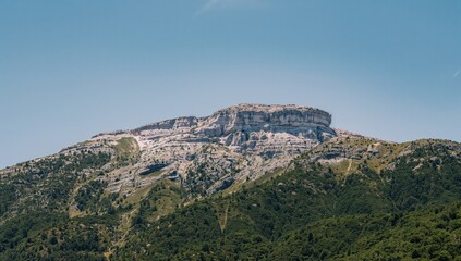 Obraz premium Snowy mountain peaks above forested slopes representing hiking, adventure, and outdoor exploration concept.