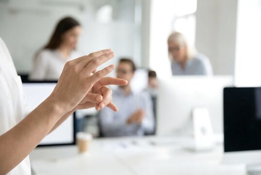 Woman communicating using sign language during business meeting in office. Symbol of inclusion and accessibility. Deaf-friendly workplace and teamwork.