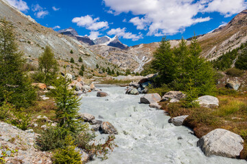 Mountain stream flowing through an alpine meadow in the Swiss Alps