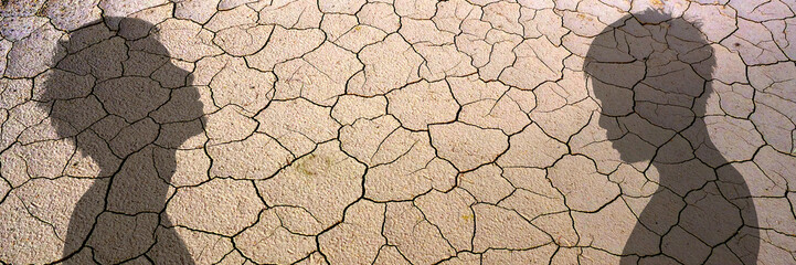 Two Silhouettes with Shadow on Cracked Ground, evoking a sense of introspection and isolation. The textured ground adds depth to the scene