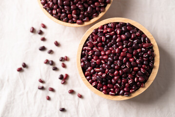 Azuki beans, Adzuki bean or red mung beans in wooden bowl on white fabric background, Food ingredients in many Chinese dishes and filling in Japanese sweet