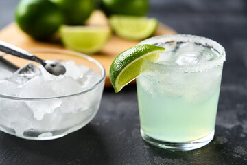 glass with fresh homemade margarita cocktail on a black table, selective focus.