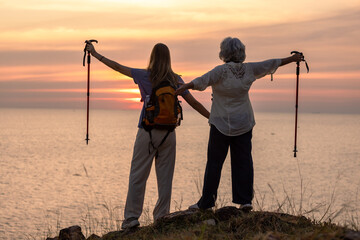 Mother and Daughter Hiking Together at Sunset by the Sea