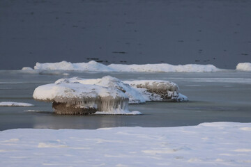 frozen pieces of ice on the seashore in the winter cold and frost