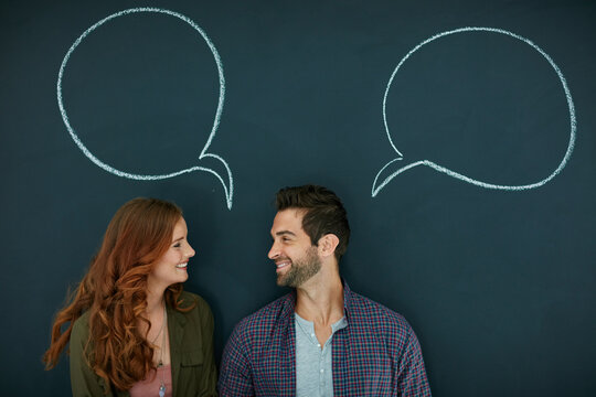 Couple, speech bubble and happy by chalkboard with idea, opinion or mockup space with dialogue. People, partner and smile with talk, social media or emoji with chat icon, sign or love in relationship - Powered by Adobe