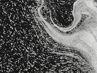 Swirling foam texture on water creating abstract pattern