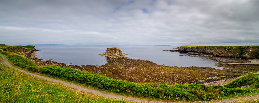 Thurso bay coastline view with sea stack and winding path in Scotland