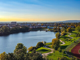 Fototapeta premium Aerial view of a European city with autumn trees and mountains.
