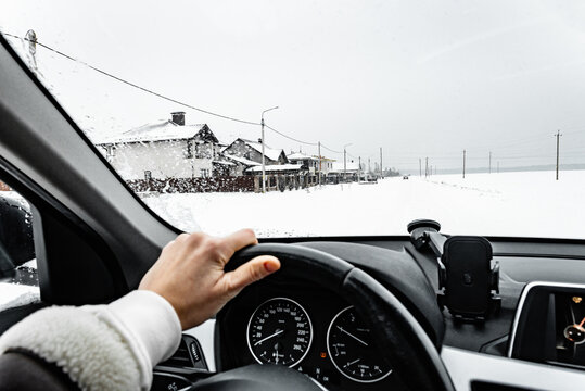 Driver's hands on the steering wheel of a car and controlling the car. Car trips and driving in winter.