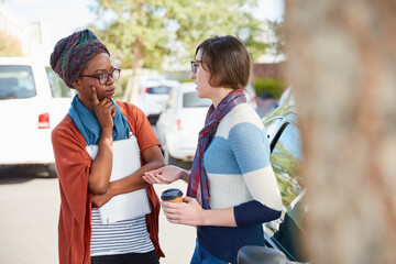 University, outdoor and women on campus for talking, conversation and listening at college. Academy, students and people with chat, speaking and discussion for education, learning and studying