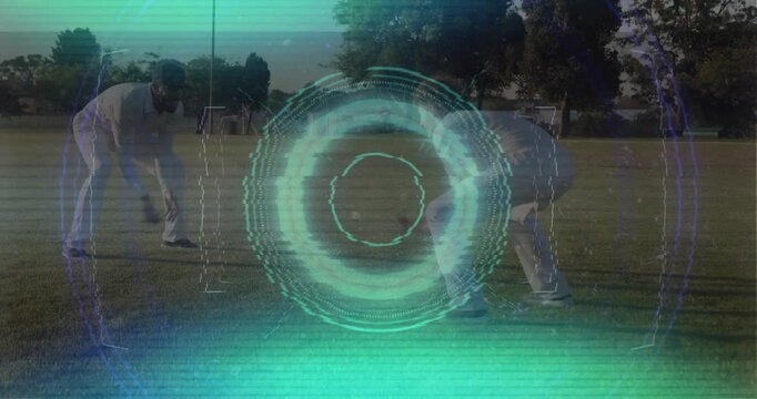 Two cricket players bending to pick up ball, placing on crease preparing drill teal HUD overlaying
