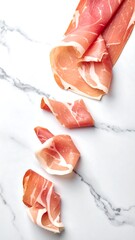 Cured ham slices, arranged against a stark white marble. Elegant presentation