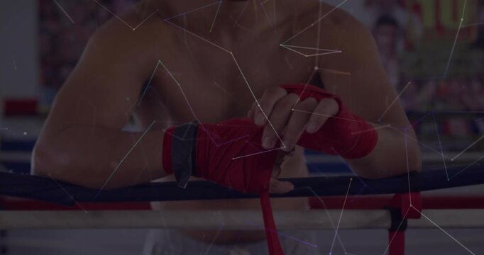 Boxer pulling red wrap and initiating wrist support while tightening knuckles for boxing training