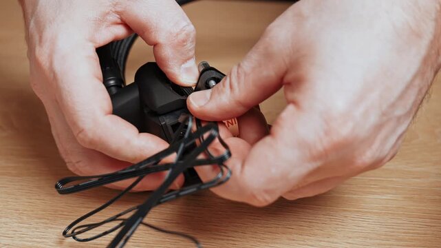 A cooling block for a desktop processor. This part is used for PC assembly. A close-up of hands installing a cable into the CPU cooling pump housing.