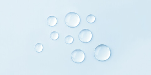 Transparent drops of cosmetics on a blue background