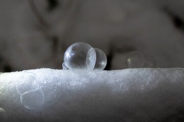 Frozen soap bubbles in the snow, on a cold winter day