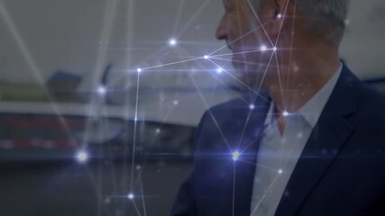 Animation of network of connections over caucasian businessman using smartwatch at an airport