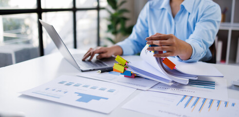 Businesswoman hands working in Stacks of paper files for searching and checking unfinished document achieves on folders papers at busy work desk office   © groviapoto