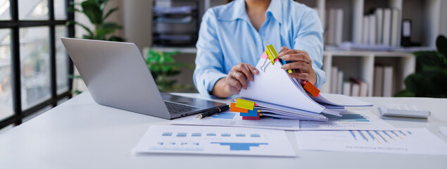 Businesswoman hands working in Stacks of paper files for searching and checking unfinished document achieves on folders papers at busy work desk office   © groviapoto