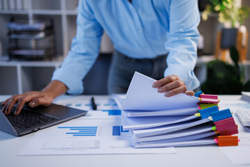 Document management. Businesswoman working with stack of paper files for searching and checking corporate files, document achieves on folders paper on office table, closeup   © groviapoto