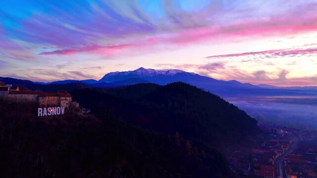 Aerial drone timelapse of Rasnov Fortress in Romania during a winter sunset.