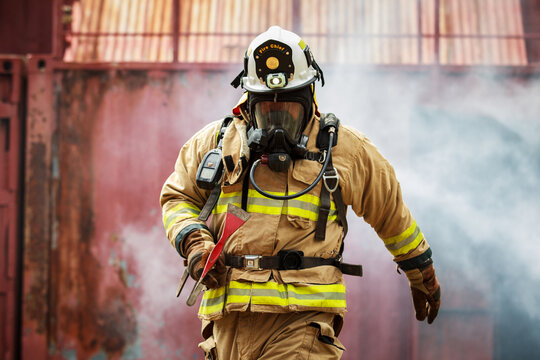 Firefighter wearing breathing mask standing in smoke during emergency operation