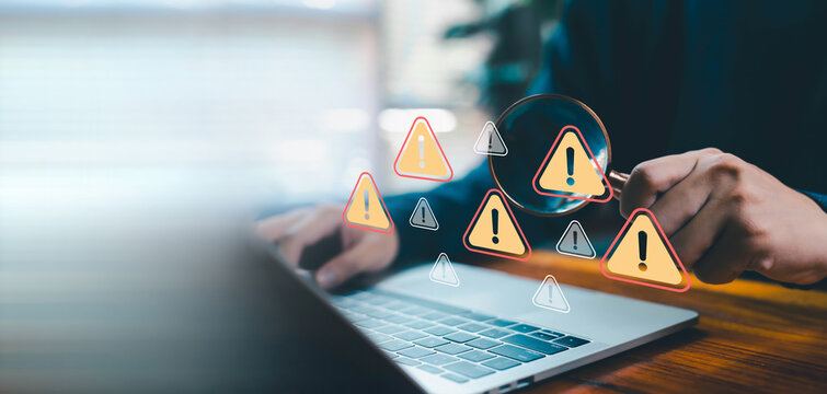 Business professional analyzing laptop data with magnifying glass and warning alert icons, representing risk assessment, cybersecurity threat detection, system audit, software error, data protection. - Powered by Adobe