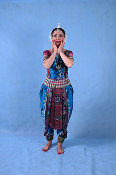 Indian dancer in the studio on a blue background in a dance pose