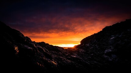 Dramatic sunset over rugged volcanic rock formations sculpted by coastal erosion