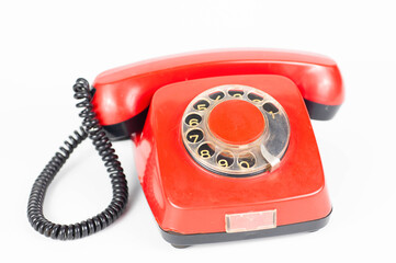 Old red telephone on white