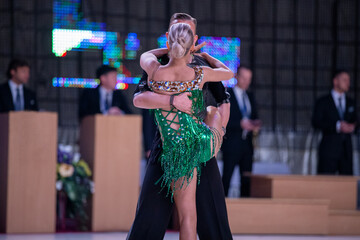 Ballroom dancer couple in passionate embrace, where woman has one leg lifted against man during dramatic latin dance performance © Real Sports Photos