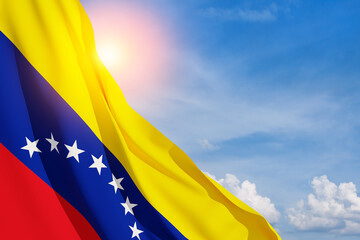 Fototapeta premium Venezuela flag on background of blue sky. Patriotic concept. Banner with place for text.