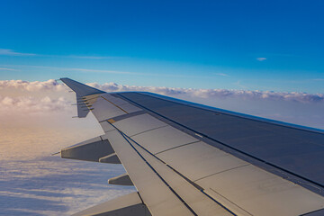 An airplane against a beautiful blue sky with clouds. Cloudy sky, weather, nature, blue clouds.
