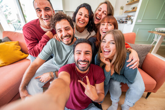 Group of friends taking selfie with smart mobile phone device at home - Happy young people smiling together at camera - University students having fun together in college campus - Friendship concept