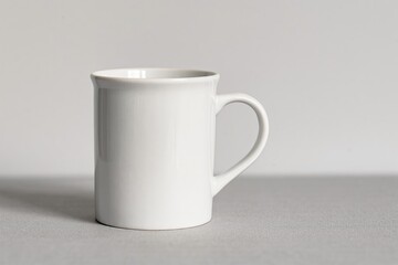 Obraz premium A sleek and modern white mug that elegantly showcases simplicity against a soft gray backdrop behind it