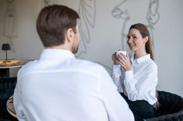 Obraz premium Colleagues having coffee at the office kitchen and having a talk