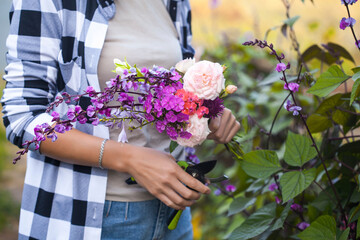 girl gardener prunes flowers in the garden with secateurs
