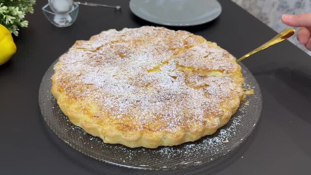 Cutting and serving a delicious homemade custard cream pie with powdered sugar