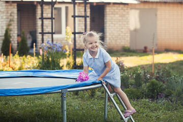 Little girl on a trampoline on a summer day.
