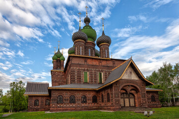Old Russian Orthodox brick church with green domes under blue sky