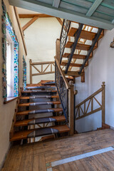 Rustic Wooden Staircase with Wrought Iron Railing and Natural Light